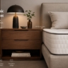 A beautiful, modern bedroom featuring a Home Decor Indonesia bedside table placed next to a thick mattress.