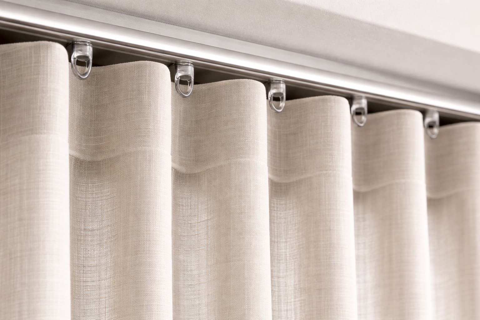 An extreme close-up of the curtain header, showing the perfect, uniform waves of the fabric hanging from a premium aluminum track.