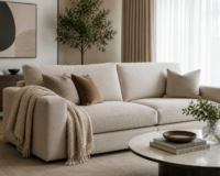 A bright, inviting shot of a beautifully reupholstered modern sofa. Place a cozy throw blanket over the armrest to emphasize the casual, accessible vibe.